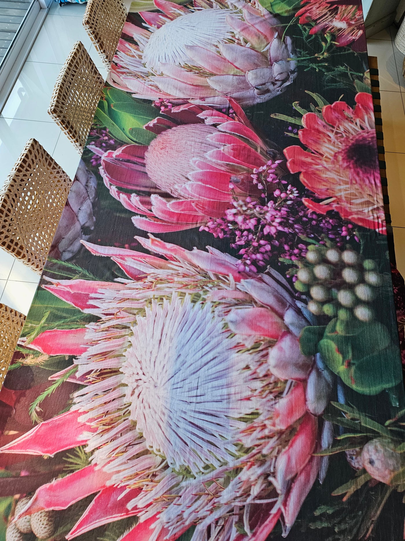 Protea Tablecloth on a long display dining table with chairs