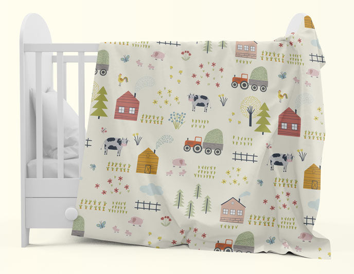 cuddle blanket with farm print hung over cot