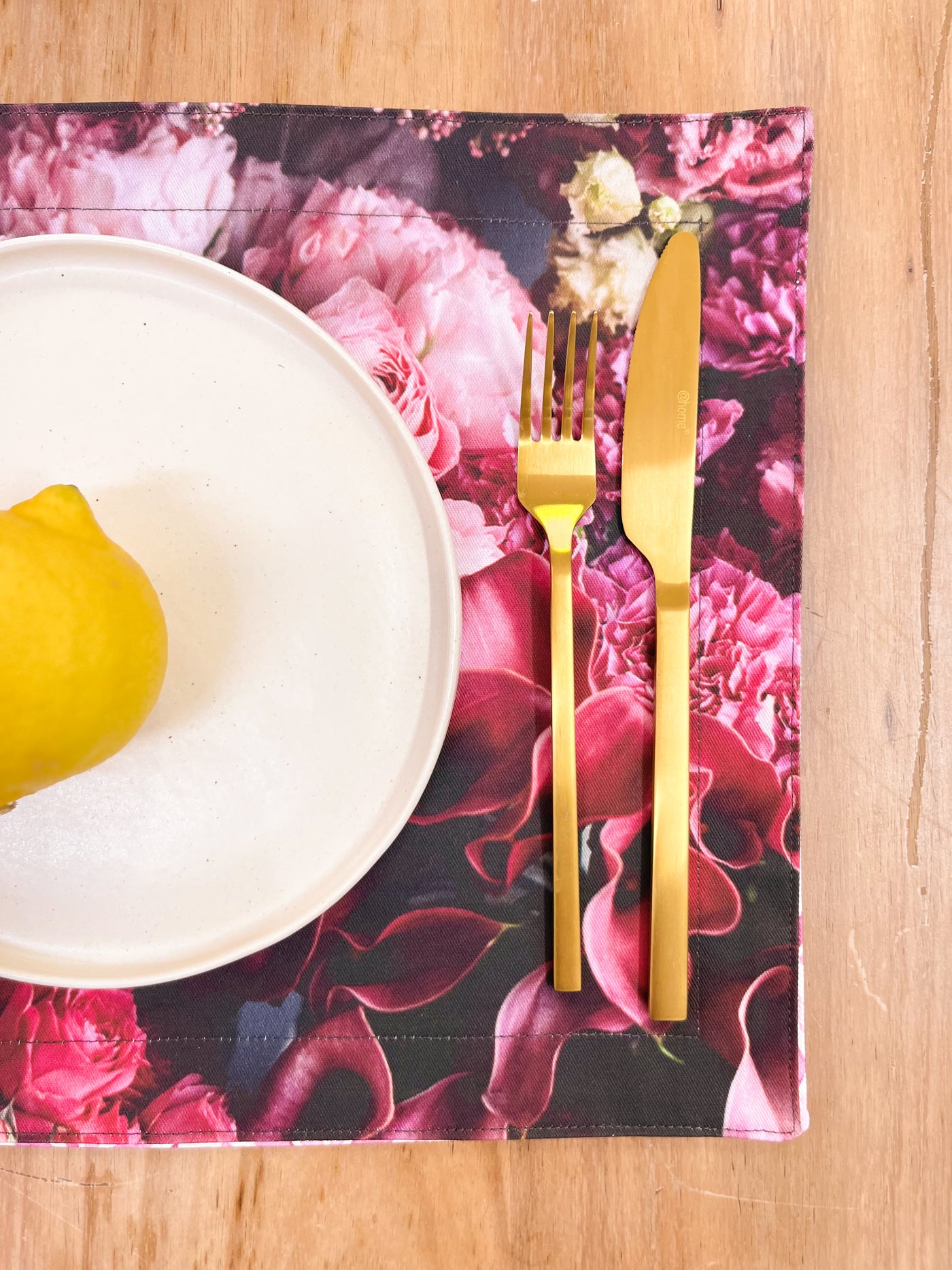 Lemon on White Crockery with Golden Utensils on Floral Placemat