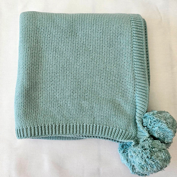 mint blanket with pompoms