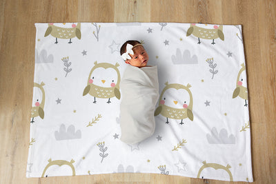 Baby wrapped in blanket on a designer blanket