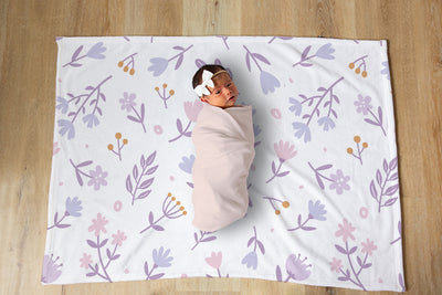 Baby wrapped in blanket on a designer blanket